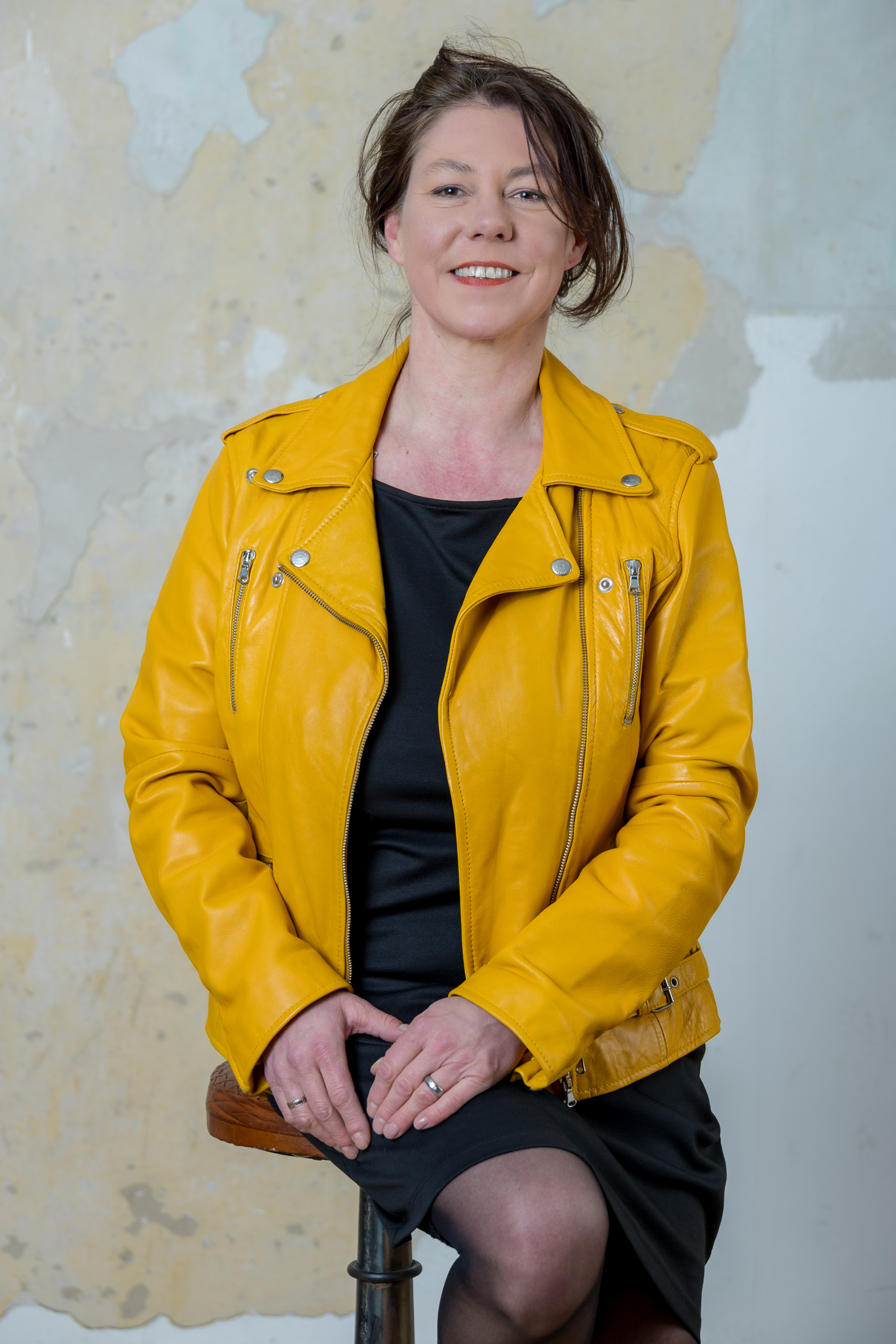 Portrait von Andrea Stellbrink in gelber Jacke