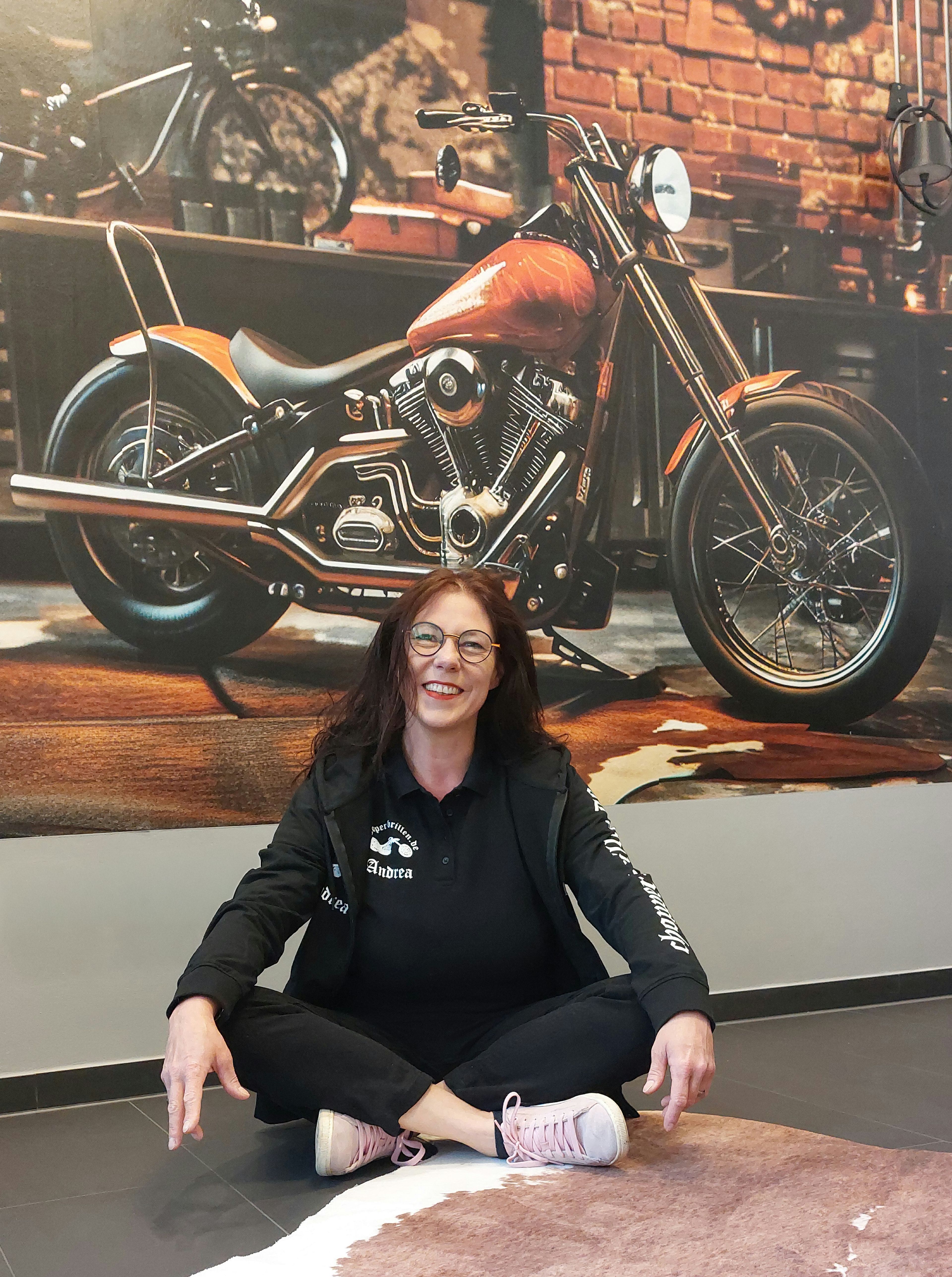 Andrea Stellbrink vor einer Tapete mit einem Motorrad